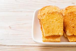 Baked crispy bread with butter and sugar on plate photo