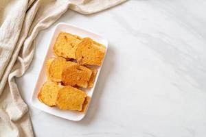 Baked crispy bread with butter and sugar on plate photo