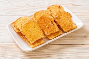 Baked crispy bread with butter and sugar on plate