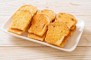 Baked crispy bread with butter and sugar on plate