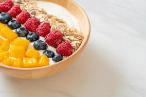 Homemade yogurt bowl with raspberry, blueberry, mango, and granola - healthy food style photo