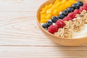 Homemade yogurt bowl with raspberry, blueberry, mango, and granola - healthy food style photo