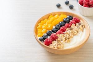 Homemade yogurt bowl with raspberry, blueberry, mango, and granola - healthy food style photo