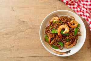 Stir-fried yakisoba noodles with green peas and shrimps - Asian food style photo