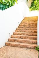 Paso de escalera de ladrillo al aire libre con pared blanca