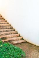 Paso de escalera de ladrillo al aire libre con pared blanca foto
