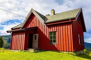 Beautiful red wooden cabin hut on hill in Norway nature. photo