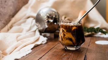 Barista pouring milk into a glass of iced coffee photo