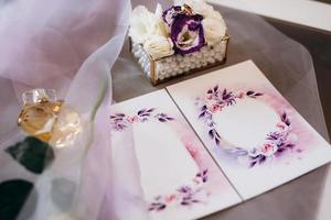 wedding invitation in a gray envelope on a table with green sprigs photo