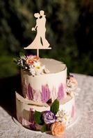 wedding cake on a wooden bench against a waterfall background photo