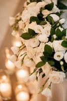 el presidium de los recién casados en el salón de banquetes del restaurante está decorado con velas y plantas verdes