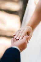 the bride and groom tenderly hold hands between them love and relationships photo