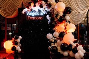 a photo zone themed angels and demons in black with white and black balls