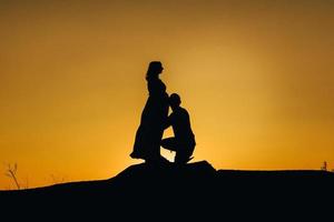 silhouettes of a happy young happy family against an orange sunset photo