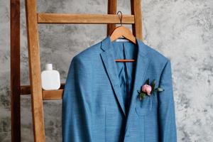 Traje clásico azul blazer colgando de una escalera de madera foto