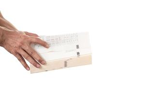 Man's hand holding and opening a thick book on white background photo