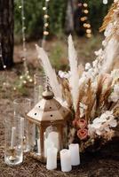 Área de ceremonia de boda con flores secas en un prado en un bosque de pinos foto