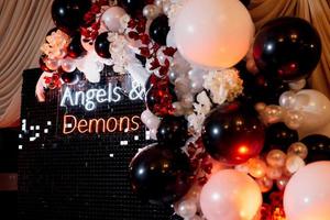 a photo zone themed angels and demons in black with white and black balls