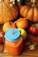 Glass of fresh pumpkin smoothie on a wooden background. photo