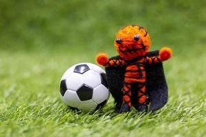 Soccer ball with ghost are on green grass on Halloween day photo