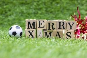 Soccer ball with Merry Xmas text on green grass photo