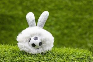 Balón de fútbol con decoración de vacaciones de Pascua sobre fondo de hierba verde foto