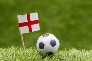 Soccer ball with flag of England on green grass photo