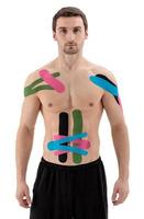 Atleta profesional masculino con cinta de kinesiología en el vientre y el hombro. deporte y rehabilitación, tratamiento de kinesioterapia