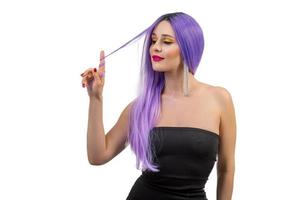 Retrato de una hermosa joven con un elegante maquillaje brillante y una peluca violeta aislado sobre fondo blanco.