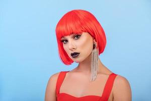 Pretty woman in red wig over blue background photo