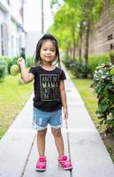 Little girl with a mango in her hand photo