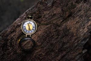Vintage pocket watch on the old wooden background with copy space photo