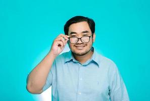 The young man was holding glasses with a big smile. blue background photo