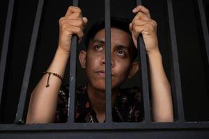 expression of man holding bars in prison photo