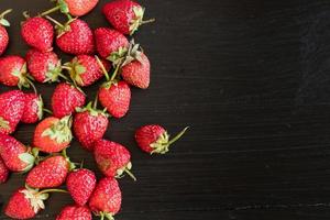 Fresas frescas sobre fondo vintage de madera negra foto