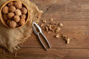 Granos de nueces en un tazón de madera, vista superior de alimentos saludables de nueces foto