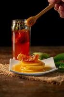 jugo de limón con miel en la mesa de madera, limones y hojas de salvia