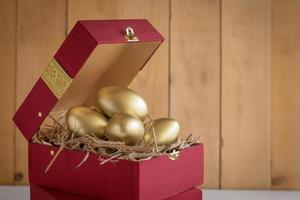 exito financiero. huevo dorado en una caja de regalo roja foto