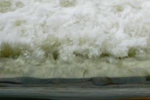 Motion blur of Powerful waves water with white foam rising up photo