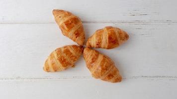 Croissants frescos sobre fondo de madera blanca, vista superior y espacio de copia foto