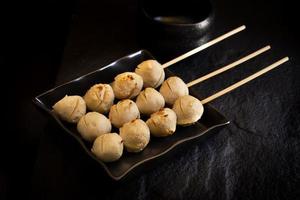 Roasted pork ball in black plate on dark background photo