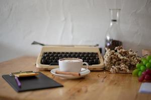 Vintage typewriters and Cup of Coffee on wooden table photo