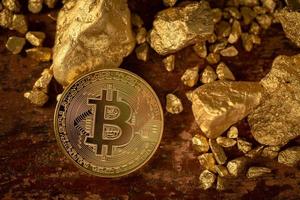 bitcoin de oro bitcoin-criptomoneda física y granos de pepita de oro. concepto de negocio foto