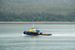 Pequeño remolcador en movimiento en la bahía en Alaska foto