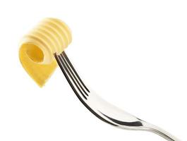 Rizo de mantequilla en un tenedor aislado en blanco foto