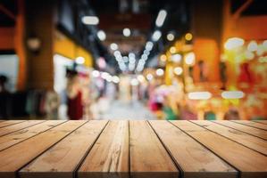 mesa de madera en bokeh abstracto del centro comercial. para exhibir o montar sus productos. foto