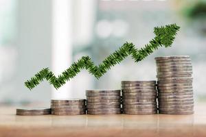 Business and finance growth concept. green leaf growing graph on silver coin stack. photo