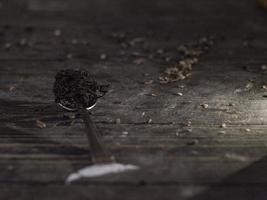Dry black tea leaves on metal spoon photo