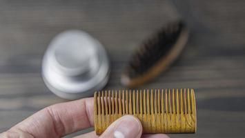 peine de barba de madera en una mano masculina foto