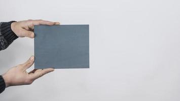 manos de hombre sosteniendo placa de identificación en blanco gris foto